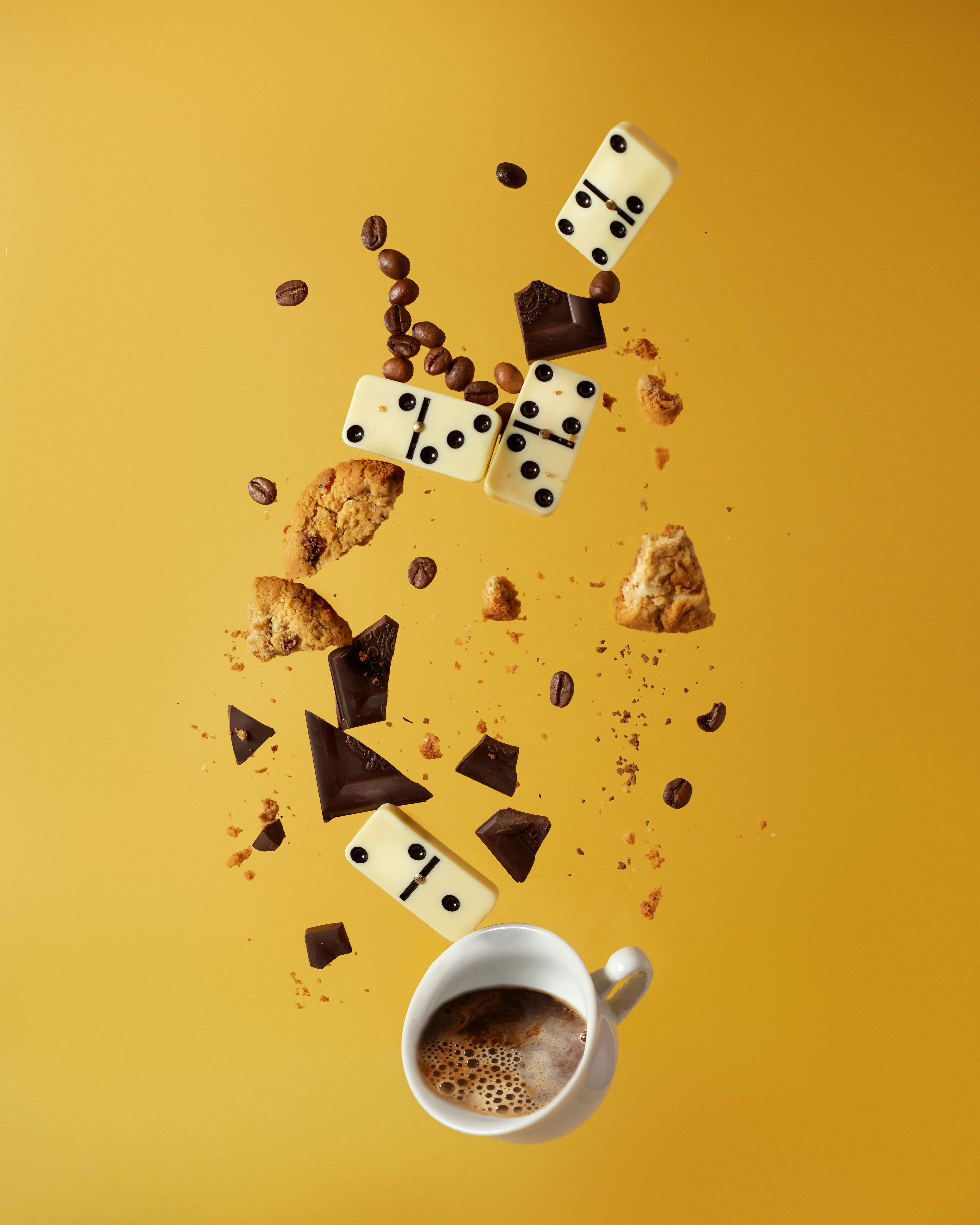 white ceramic mug with coffee beside brown and white cookies